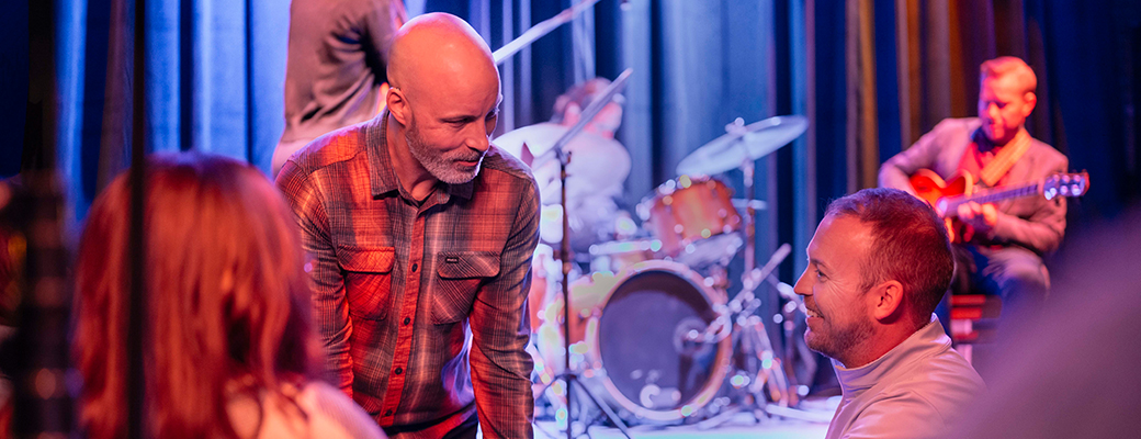 Image of male hearing aid wearer serving customers at his music venue